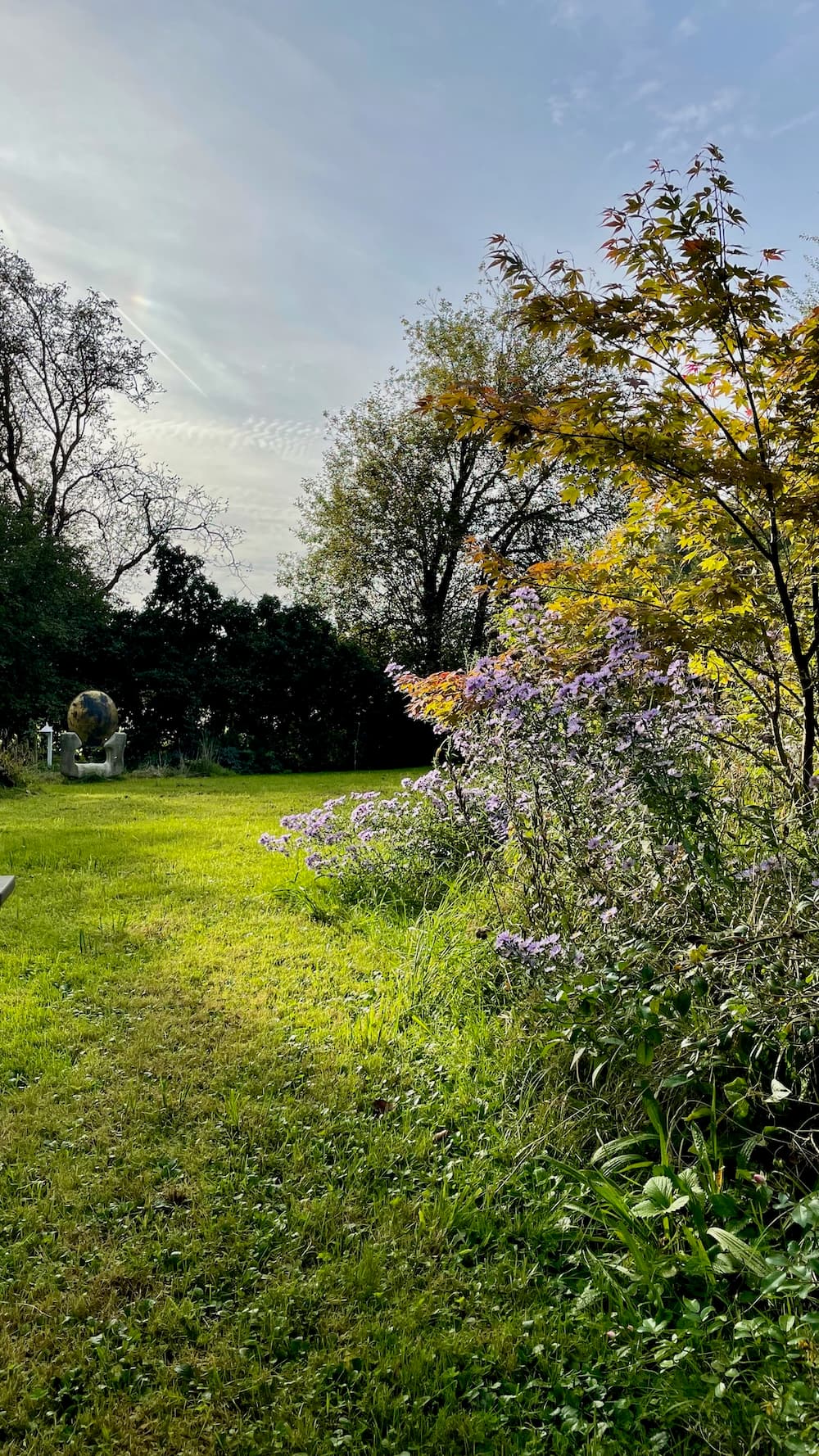 Idyllischer Gartenweg mit Blumenbeeten und natürlicher Umgebung